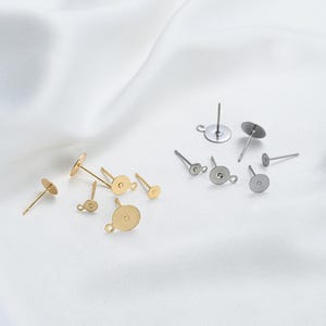 Puede incluir: Surtido de hallazgos para pendientes de oro y plata. Los hallazgos están hechos de metal y tienen una forma redonda. Se utilizan para sujetar los pendientes a los lóbulos de las orejas.