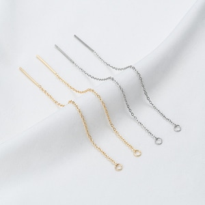 Op de afbeelding: Drie paar oorbelkettingverlengers, twee goudkleurig en één zilverkleurig, met een kleine lus aan het einde van elke ketting.