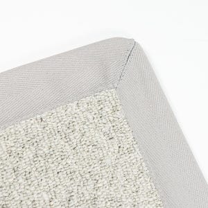 May include: Close-up of a grey woven rug with a light grey canvas border. The rug has a textured, hand-woven look.