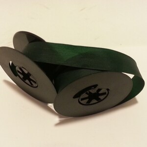 May include: Two spools of dark green ribbon, each with a black plastic center.