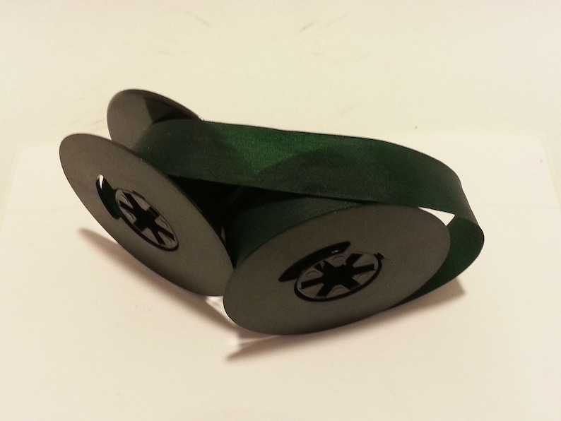 May include: Two spools of dark green ribbon, each with a black plastic center.