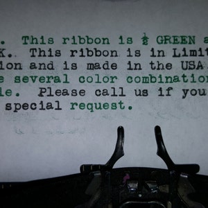 May include: Typewriter with a sheet of paper that reads "Hello. This ribbon is GREEN and BLACK. This ribbon is in Limited production and is made in the USA. We have several color combinations available. Please call us if you have a special request."