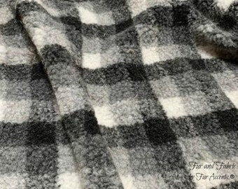 May include: Black and white fuzzy plaid fabric with a soft, fluffy texture. The fabric is perfect for crafting projects, home decor, and clothing.