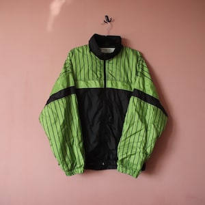 May include: A black and green striped windbreaker jacket with a zip fastening.