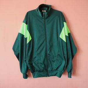 May include: A vintage track jacket in green with lime green accents. The jacket features a zip fastening and contrasting lime green panels on the shoulders and sleeves.