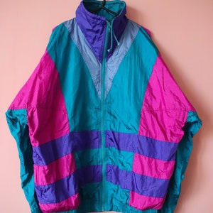 May include: A vintage 90s style jacket with a teal, purple, and pink color block design. The jacket has a zipper closure and a drawstring hood.