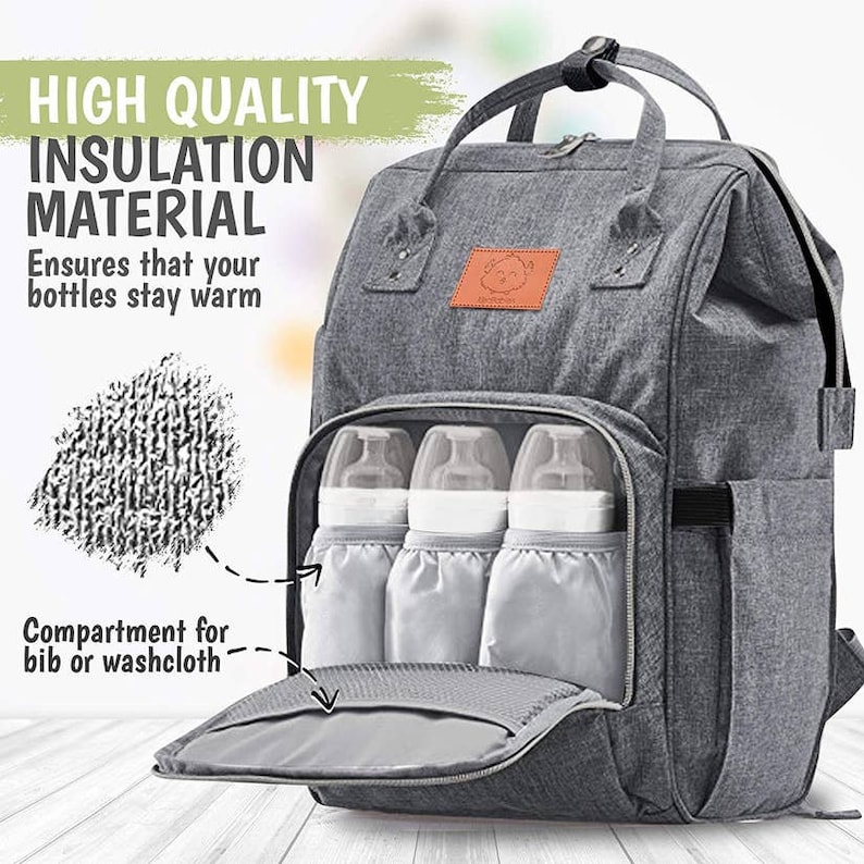 May include: Gray diaper bag backpack with insulated bottle holders and a zippered compartment for a bib or washcloth. The bag has a brown leather patch with a logo on the front.