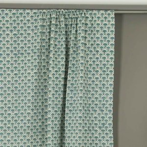 May include: A pair of curtains featuring a repeating teal floral pattern on a cream background. The fabric is gathered at the top along a silver curtain rod, creating vertical folds that drape downward in a consistent, structured arrangement.