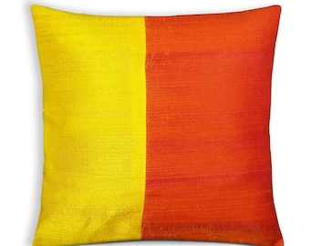 May include: Square decorative pillow with a vibrant color block design. The pillow features a vertical split, with one half in a bright yellow and the other in a warm orange. The fabric has a subtle sheen, suggesting a silk or satin material.