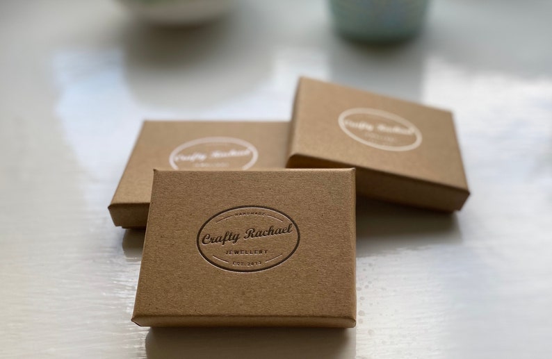 May include: Three brown cardboard boxes with the text "Crafty Rachael Jewellery" embossed on the top box.