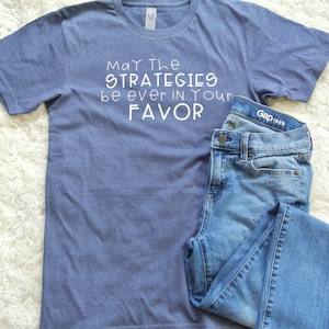 May the Strategies be ever in your Favor T-Shirt | Unisex Crew Neck T-Shirt | Unisex 3/4 Baseball T-Shirt | Multiple Colors Available