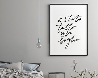Puede incluir: Una impresión enmarcada en blanco y negro con el texto "E stato tutto un sogno." en estilo manuscrito. La impresión está colgada en una pared gris en un dormitorio.