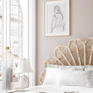 K&ouml;nnte beinhalten: Ein wei&szlig;es Bett mit einem geflochtenen Kopfteil in Form eines F&auml;chers. Das Bett hat wei&szlig;e Bettw&auml;sche und ein Kissen mit einem wei&szlig;en Korallenmuster. Eine wei&szlig;e Lampe mit einem wei&szlig;en Schirm steht auf einem Nachttisch neben dem Bett. Ein gerahmtes Schwarzwei&szlig;-Strichbild einer Frau h&auml;ngt an der Wand hinter dem Bett.