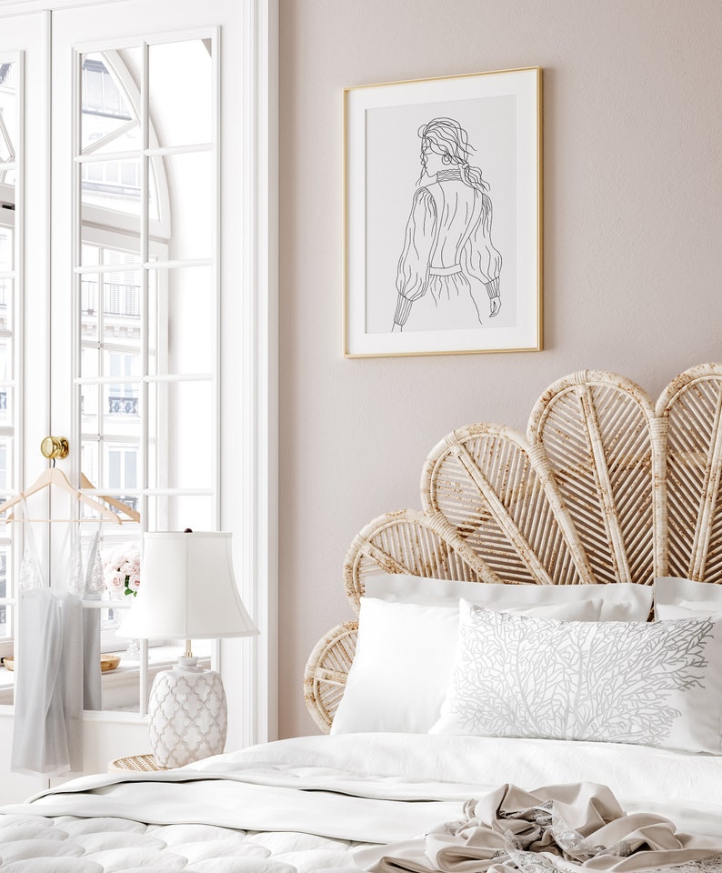 K&ouml;nnte beinhalten: Ein wei&szlig;es Bett mit einem geflochtenen Kopfteil in Form eines F&auml;chers. Das Bett hat wei&szlig;e Bettw&auml;sche und ein Kissen mit einem wei&szlig;en Korallenmuster. Eine wei&szlig;e Lampe mit einem wei&szlig;en Schirm steht auf einem Nachttisch neben dem Bett. Ein gerahmtes Schwarzwei&szlig;-Strichbild einer Frau h&auml;ngt an der Wand hinter dem Bett.