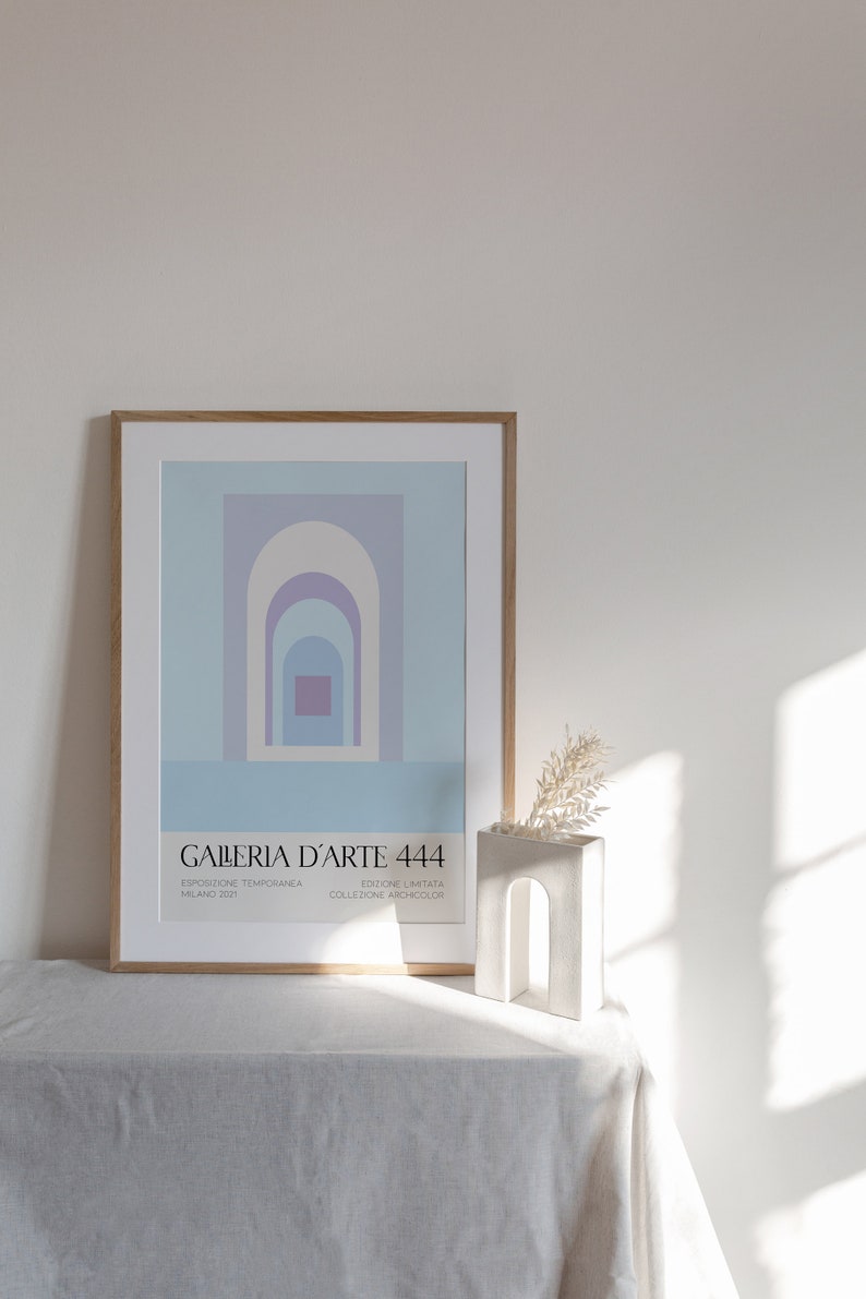 Peut inclure: Une affiche encadr&eacute;e avec un motif g&eacute;om&eacute;trique d'arches superpos&eacute;es dans des tons de bleu, violet et blanc. L'affiche est intitul&eacute;e "GALLERIA D'ARTE 444" et comprend le texte "ESPOSIZIONE TEMPORANEA MILANO 2022 EDIZIONE LIMITATA COLLEZIONE ARCHICOLOR".