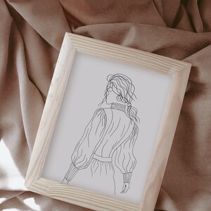 K&ouml;nnte beinhalten: Eine gerahmte Linienzeichnung einer Person mit langen Haaren, die ein lang&auml;rmliges Kleid tr&auml;gt. Die Zeichnung ist in Schwarzwei&szlig; und auf wei&szlig;em Hintergrund.