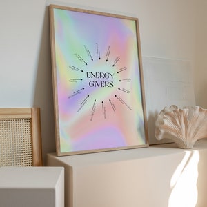 Puede incluir: Una impresi&oacute;n enmarcada con un fondo hologr&aacute;fico que presenta un dise&ntilde;o circular con flechas que apuntan a palabras que dan energ&iacute;a, como la risa, la lectura, la naturaleza y la luz del sol. El texto "ENERGY GIVERS" est&aacute; en el centro del dise&ntilde;o.