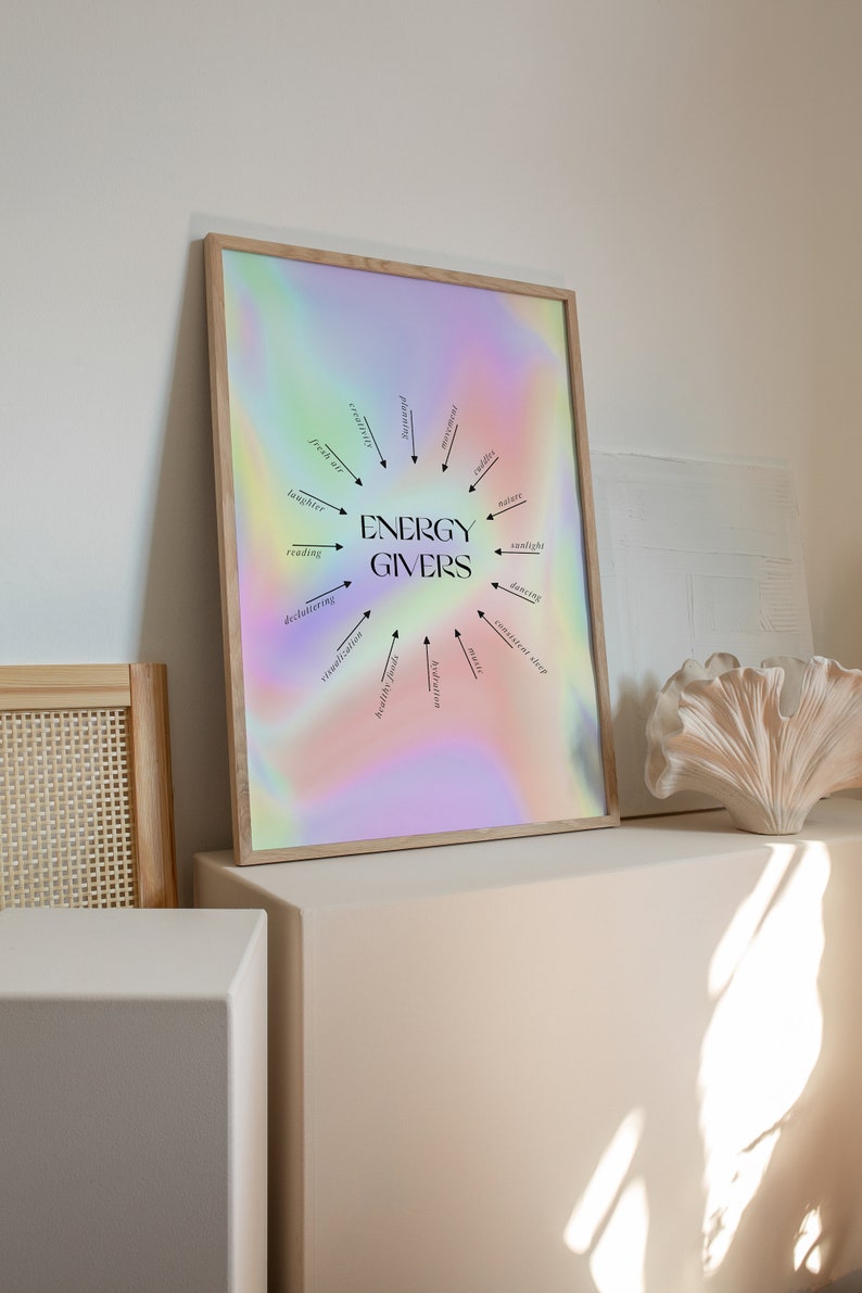 Puede incluir: Una impresi&oacute;n enmarcada con un fondo hologr&aacute;fico que presenta un dise&ntilde;o circular con flechas que apuntan a palabras que dan energ&iacute;a, como la risa, la lectura, la naturaleza y la luz del sol. El texto "ENERGY GIVERS" est&aacute; en el centro del dise&ntilde;o.