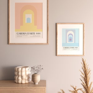 Peut inclure: Deux impressions d'art abstrait encadr&eacute;es avec un sch&eacute;ma de couleurs pastel. Les impressions pr&eacute;sentent des formes g&eacute;om&eacute;triques et des arches. Les impressions sont accroch&eacute;es &agrave; un mur gris clair au-dessus d'une table en bois avec deux vases d&eacute;coratifs.