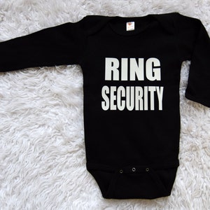 May include: Black long-sleeve baby onesie with white text that reads "RING SECURITY".