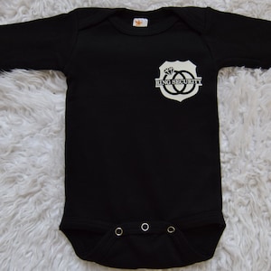 May include: Black long-sleeve bodysuit with a white graphic of a shield with two interlocking rings and the text "Ring Security".
