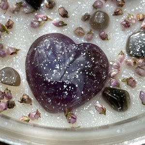 Peut inclure: Un cristal d'am&eacute;thyste en forme de c&oelig;ur de couleur violette incrust&eacute; dans une bougie blanche avec des paillettes et des fleurs s&eacute;ch&eacute;es.