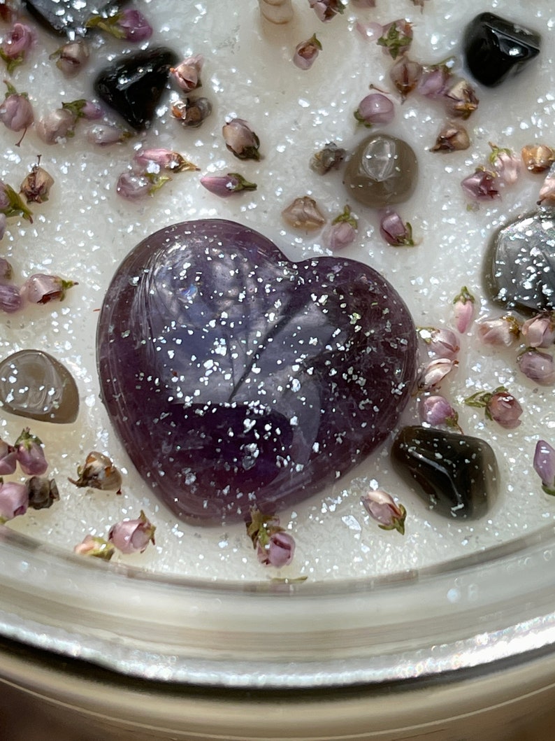 Peut inclure: Un cristal d'am&eacute;thyste en forme de c&oelig;ur de couleur violette incrust&eacute; dans une bougie blanche avec des paillettes et des fleurs s&eacute;ch&eacute;es.