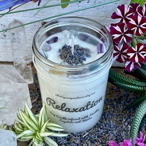 May include: A white soy candle in a clear glass jar with a label that reads "Relaxation Soy Candle infused with Healing Crystals and Herbs" and a decorative top with lavender buds and clear crystals.