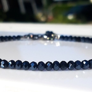 a blue beaded necklace on a white surface
