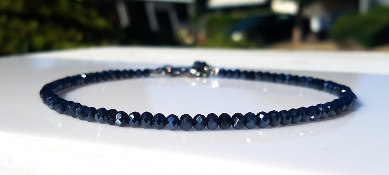 a blue beaded necklace on a white surface
