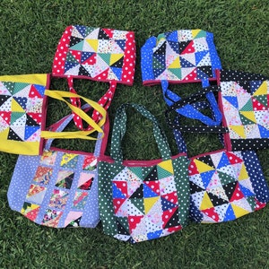 Pu&ograve; includere: Sette borse tote in patchwork colorate con tessuto a pois e manici di diversi colori. Le borse sono realizzate con diversi tessuti con un design a patchwork.