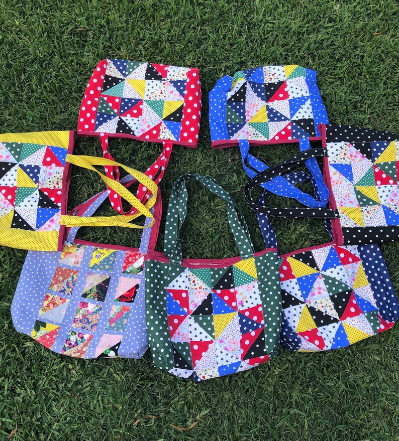 Pu&ograve; includere: Sette borse tote in patchwork colorate con tessuto a pois e manici di diversi colori. Le borse sono realizzate con diversi tessuti con un design a patchwork.