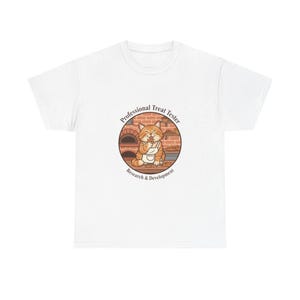Könnte beinhalten: Weißes T-Shirt mit einem Cartoon-Kater, der eine Schürze trägt und einen Leckerbissen isst. Der Kater befindet sich in einem kreisförmigen Design mit dem Text "Professional Treat Tester" und "Research & Development". Das Design beinhaltet einen Ziegelofen.