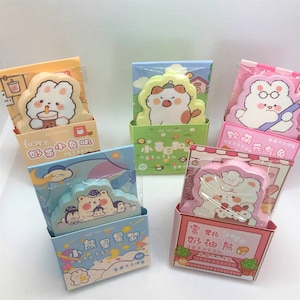 May include: Five colourful packages of sticky notes featuring cute cartoon animals. Each package has a different animal and theme, including a bunny drinking boba tea, a cat with a hat, a fish, a bear with penguins, and a bear with a cake. Each package has 60 sheets of sticky notes.