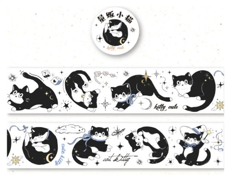 May include: A white washi tape with black and white illustrations of cats, stars, moons, and other celestial elements. The text "kitty cute" appears twice on the tape. The tape is packaged on a roll with a round sticker that says "kitty cute" in English and Japanese.