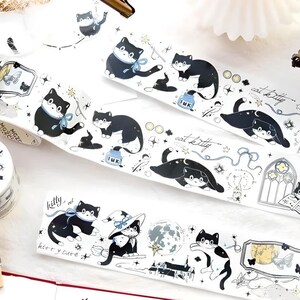 May include: A set of washi tape featuring black cats with stars, moons, and other whimsical designs. The tape is on a white background and comes in a variety of patterns.