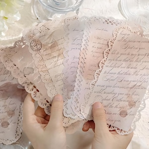 Op de afbeelding: Een set van vier vintage-achtige kaarten met kantversiering en handgeschreven berichten. De kaarten zijn versierd met delicate bloemmotieven en hebben een zachte, romantische uitstraling.