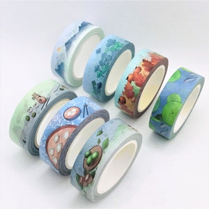 May include: Six rolls of decorative washi tape with various designs, including a blue and white mountain scene, a green clover pattern, a brown and orange autumn leaf design, a blue and green water lily pattern, a blue and white design with a bottle and a white and blue design with a bowl of dumplings.