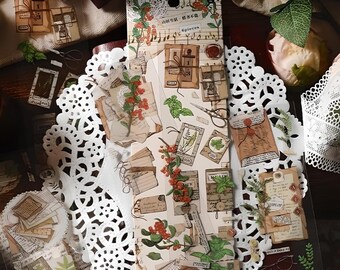 Pode incluir: Uma folha de adesivos decorativos de estilo vintage com imagens de chaves, envelopes, flores e notas musicais. Os adesivos são impressos em papel branco com um fundo marrom claro. O texto na folha diz "The Time Machine Stickers".
