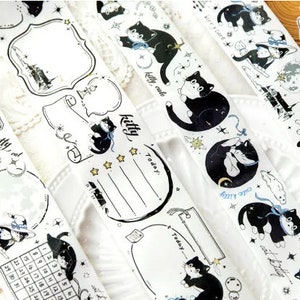 May include: Five rolls of black and white washi tape featuring cute black cats, stars, moons, and other whimsical designs. The tape is perfect for decorating planners, journals, and other paper crafts.