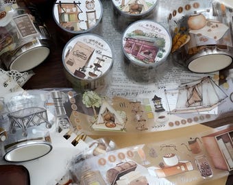 Könnte beinhalten: Sortiment dekorativer Washi-Bänder mit verschiedenen Designs, darunter ein Café, eine Camping-Szene und ein Zelt. Die Bänder sind braun, beige und weiß mit Illustrationen von Kaffeemaschinen, Campingausrüstung und Zelten.