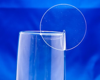 May include: A clear glass champagne flute with a clear plastic circle with a slit in the middle resting on the rim of the glass.