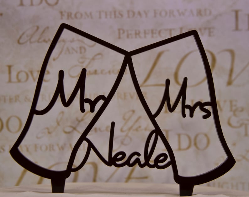 wedding cake topper with two toasting guinness beer glasses with Mr and mrs in the glasses. The topper is personalized with your last name between the glasses