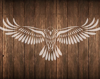 May include: White stylized illustration of an owl with outstretched wings on a wooden background. The owl design is centered and symmetrical, with detailed feather patterns. The wood has a warm, brown tone.