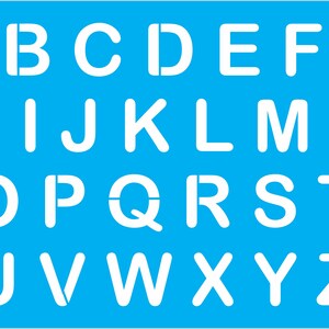 May include: A white stencil with the letters of the alphabet, A through Z, on a bright blue background.