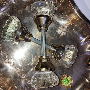 May include: Three clear glass door knobs with gold metal bases on a silver tray. The knobs have a faceted design.
