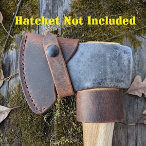 May include: A hatchet with a wooden handle and a metal blade, featuring a brown leather sheath and handle wrap. The text "Hatchet Not Included" is visible in yellow. The hatchet is set against a backdrop of moss and wood.