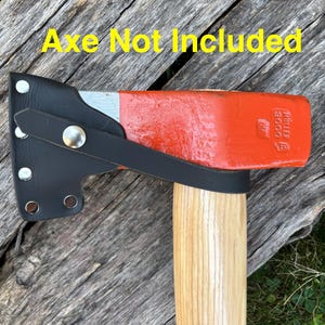 May include: Black leather axe sheath with silver rivets and a strap, protecting the red and silver axe head. The axe handle is made of light-colored wood. The text "Axe Not Included" is in yellow.