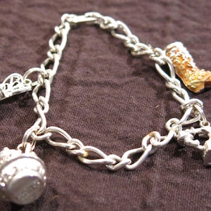 Pulsera vintage con dijes Avon y cuatro dijes Darling, 1973