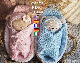 Könnte beinhalten: Zwei gehäkelte Amigurumi-Teddybären, die in Decken gewickelt sind. Der Bär links ist rosa und der Bär rechts ist blau. Die Bären befinden sich in einem Weidenkorb. Das Bild enthält den Text "LOW SEW PDF PATTERN".